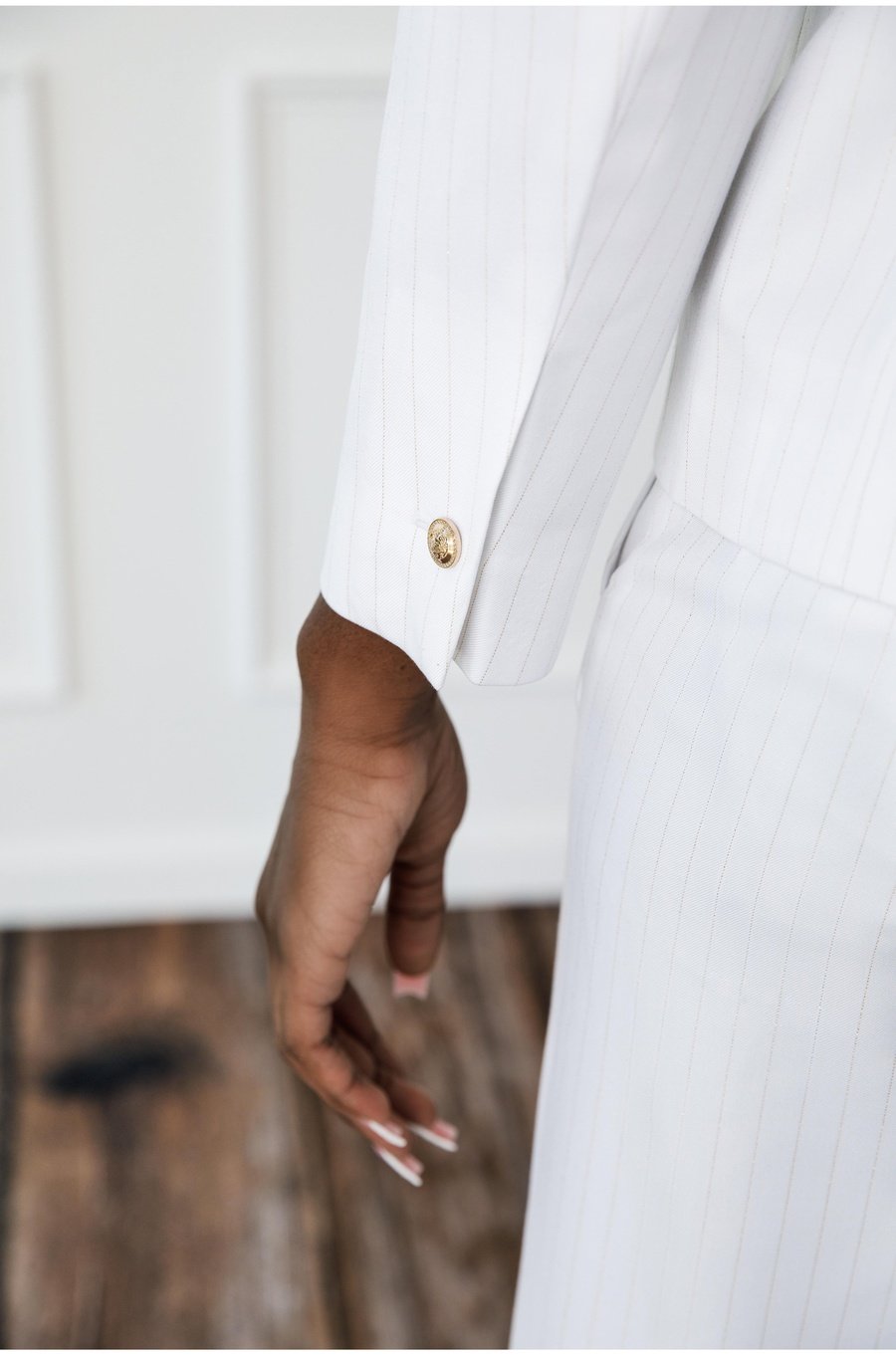 Elolo white gold pinstripe double-breasted suit. Crafted in soft poly wool and decorated with crown gold buttons